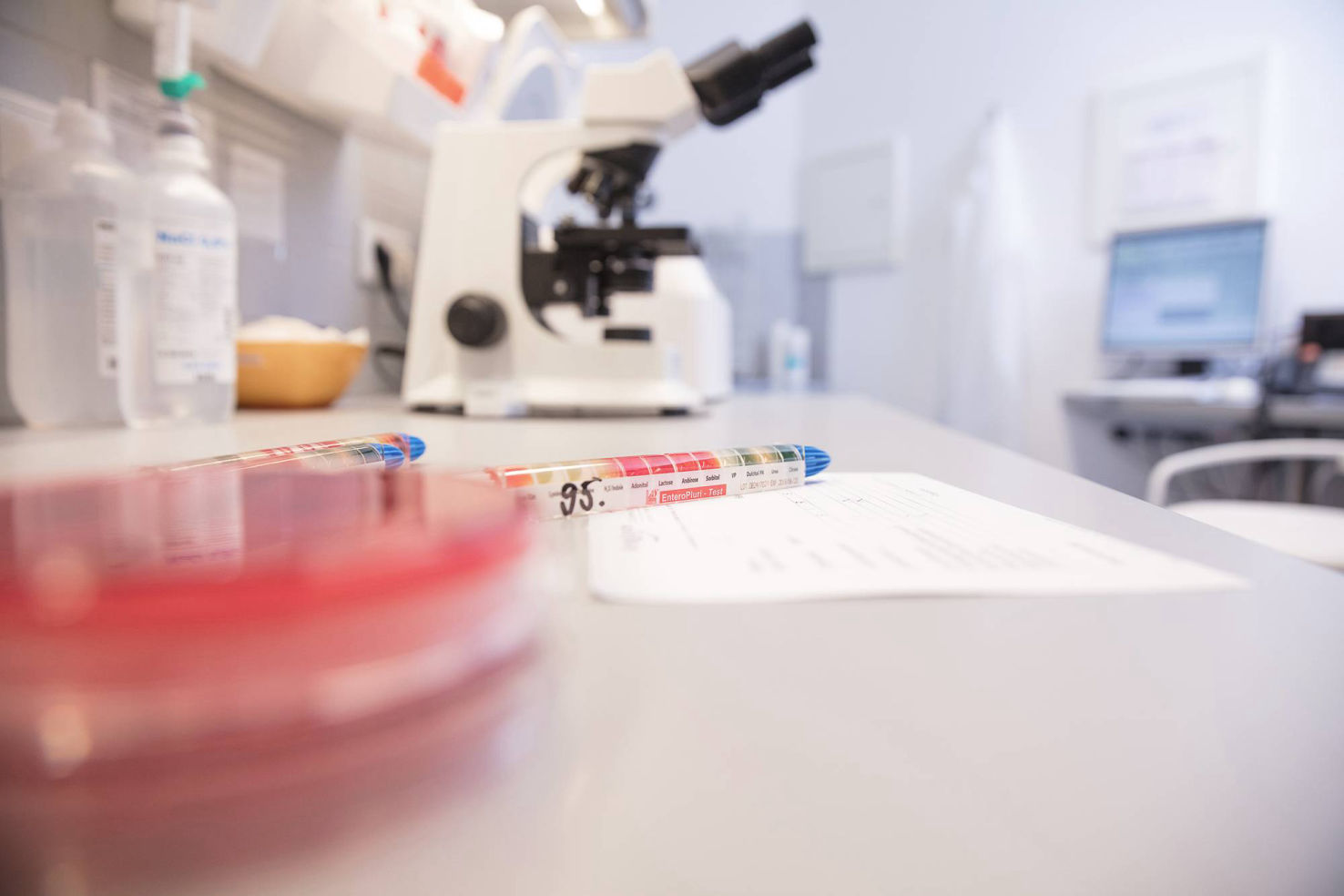 Labortisch mit Mikroskop, Papier und Stift